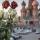 Des roses rouges et blanches fanées dans un vase. En arrière-plan, on voit la cathédrale Saint-Basile sur la place Rouge, à Moscou, avec ses multiples coupoles et dômes, qui rappellent un feu de camp montant vers le ciel.